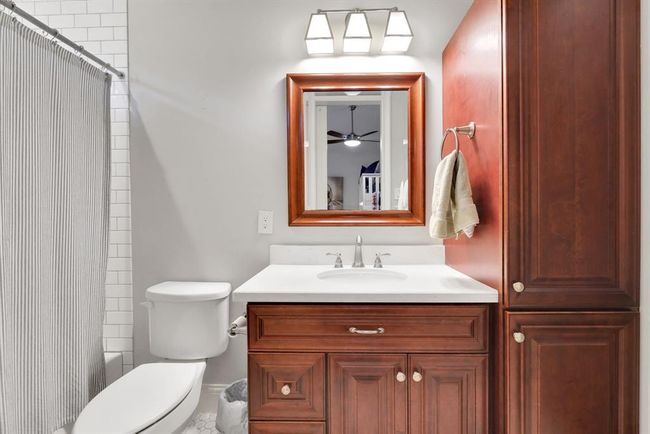 The secondary bedroom features a full ensuite bath with thoughtfully designed touches like rich wood cabinetry, quartz countertops and subway tile surround tub/shower combination along with nice walk-in closet! | Image 34