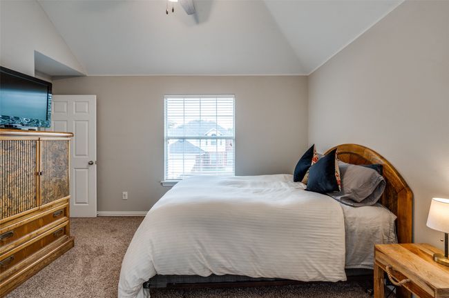Carpeted bedroom with lofted ceiling, ceiling fan and ensuite full bath. Currently used as a guest bedroom | Image 20