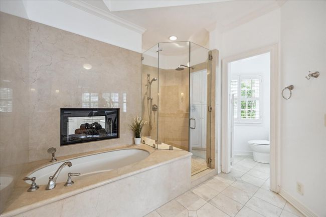 Primary bath soaking tub and walk-in shower. Enjoy a luxurious bath by the fire during the fall/winter! | Image 21