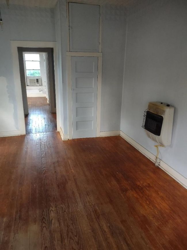 Unfurnished living room with hardwood / wood-style floors, baseboards, and heating unit | Image 22