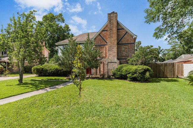 Tudor home featuring brick siding and a chimney | Image 6
