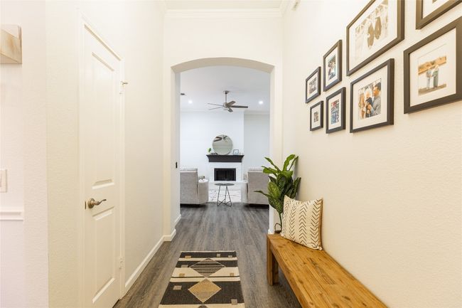 Hall featuring arched walkways, dark wood finished floors, recessed lighting, crown molding, and baseboards | Image 5