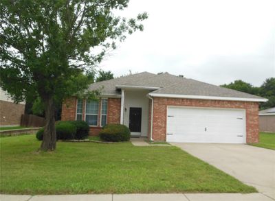 Ranch-style home featuring a garage and a front lawn | Image 2