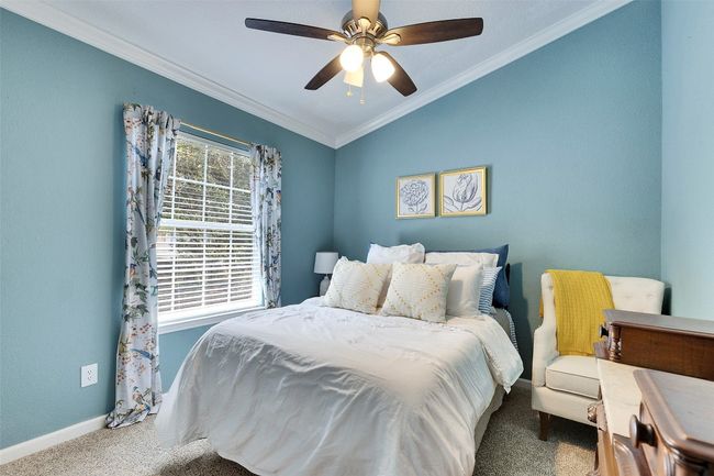 Bedroom with carpet flooring, baseboards, ornamental molding, lofted ceiling, and ceiling fan | Image 25