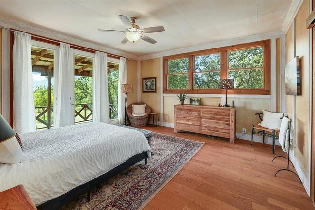 Bedroom featuring access to exterior, baseboards, a ceiling fan, wood finished floors, and ornamental molding | Image 18