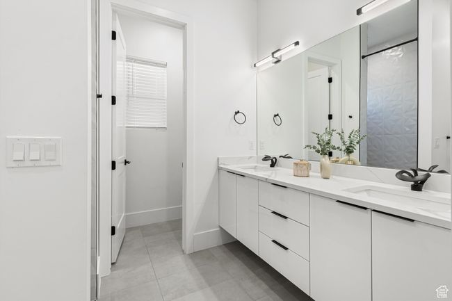 Full bath with double vanity, a sink, tile patterned flooring, and baseboards | Image 19