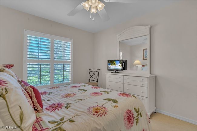 Bedroom with light colored carpet, ceiling fan, and baseboards | Image 21