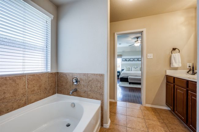 Full bath with ensuite bath, plenty of natural light, a bath, and vanity | Image 23