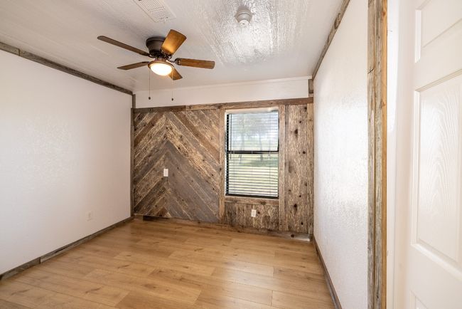 Unfurnished room with visible vents, baseboards, a ceiling fan, crown molding, and light wood finished floors | Image 22