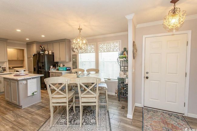 Dining space with an inviting chandelier, light wood finished floors, and crown molding | Image 5