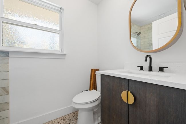 Bathroom featuring speckled floor, baseboards, toilet, and vanity | Image 20