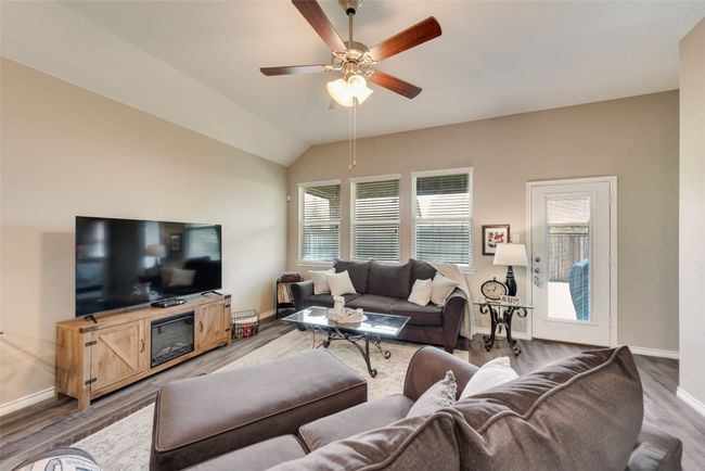 Living area with wood finished floors, a ceiling fan, and lofted ceiling | Image 16