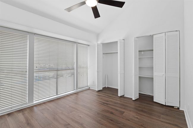 Downstairs secondary bedroom with floor to ceiling windows, custom ceiling fan and lots of closet space. | Image 17