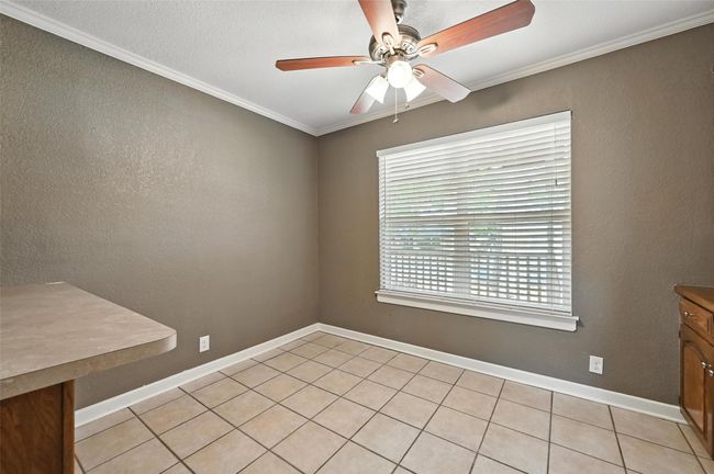 Empty room with wood finished floors, ceiling fan, and crown molding | Image 10