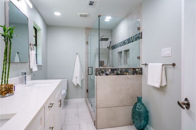 Bathroom featuring double vanity and a shower stall | Image 17