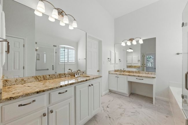 Full bath featuring high ceiling, new tile flooring, two vanities, a garden tub, and a walk in shower. | Image 20