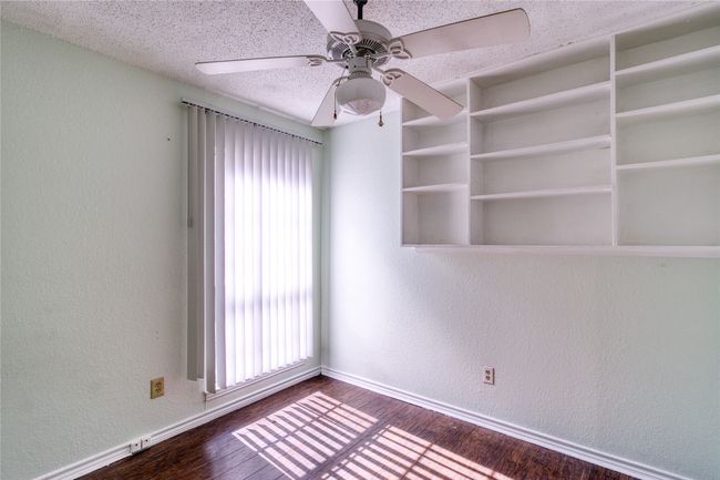 Spare room with a ceiling fan, dark wood-style floors, a textured wall, and a textured ceiling | Image 7