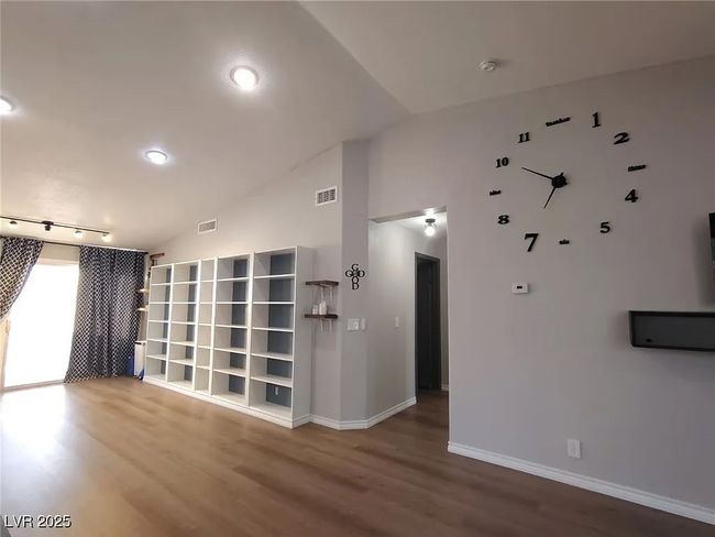 Empty room featuring vaulted ceiling, wood finished floors, and recessed lighting | Image 13