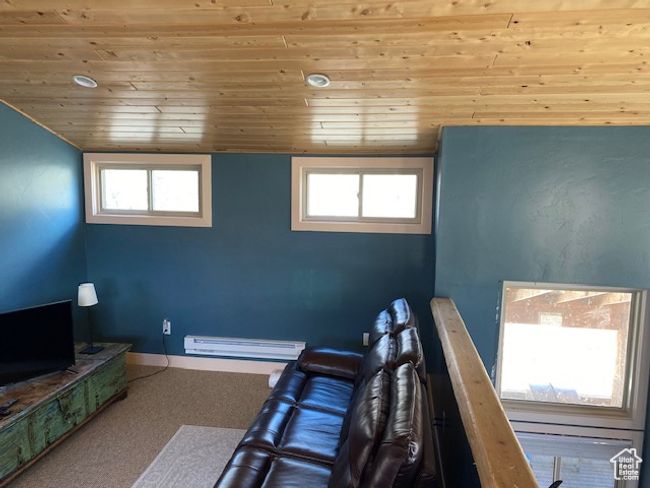 Interior space featuring a baseboard radiator, wooden ceiling, and baseboards | Image 10