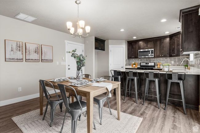 Dining room with light wood-type flooring, baseboards, a chandelier, and recessed lighting | Image 14