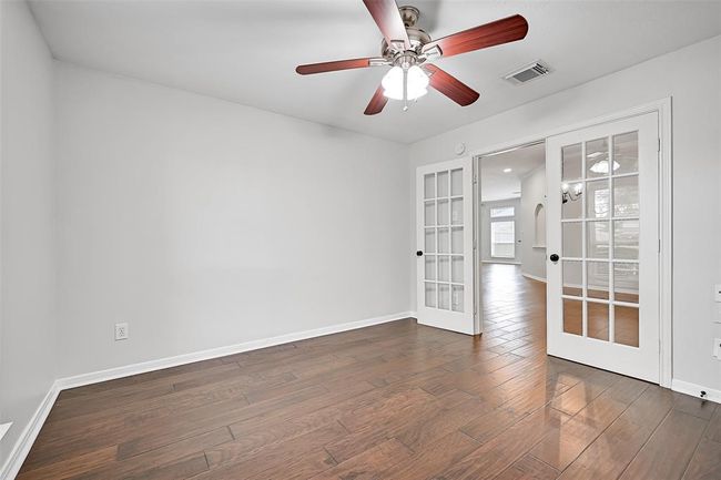 This front-facing flex-use study with glass French doors and engineered wood flooring also includes a walk-in closet—easily accommodating use as a 4th bedroom, guest room, or private office. | Image 8
