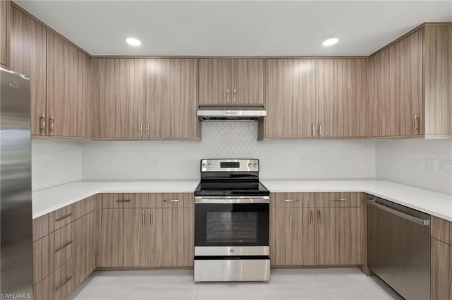 Kitchen with light tile patterned flooring and appliances with stainless steel finishes | Image 10