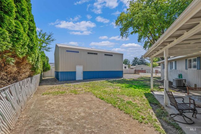 View of yard featuring an outdoor structure and a patio area | Image 28
