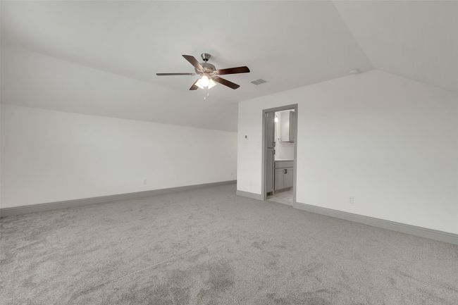 Additional living space with visible vents, baseboards, a ceiling fan, light carpet, and lofted ceiling | Image 27