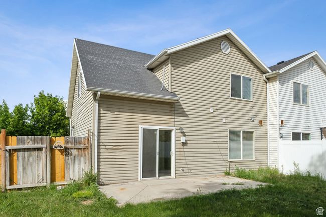 Rear view of house with roof with shingles, a gate, and a patio | Image 19