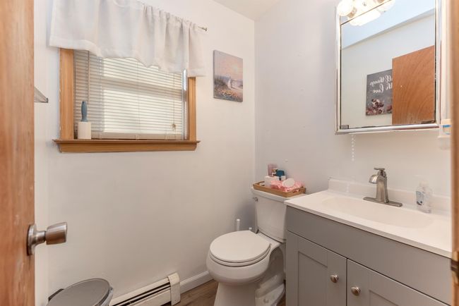 Bathroom with vanity, baseboard heating, baseboards, toilet, and wood finished floors | Image 32