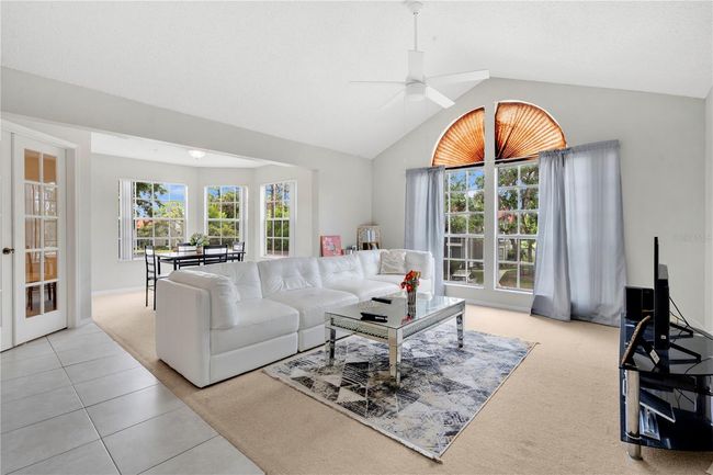 The living room with oversized windows facing the parking lot towards the west | Image 6