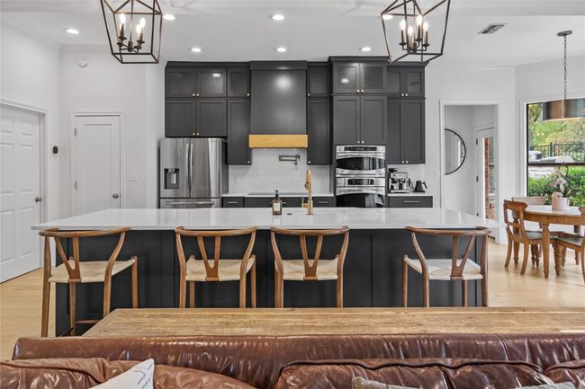 Kitchen with an inviting chandelier, appliances with stainless steel finishes, and exhaust hood | Image 20