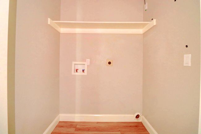 Laundry room featuring electric dryer hookup, hookup for a washing machine, and light wood-style floors | Image 24
