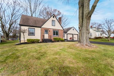 View of front of home with a front yard and a garage | Image 1