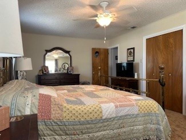 Carpeted bedroom with a textured ceiling and ceiling fan | Image 14