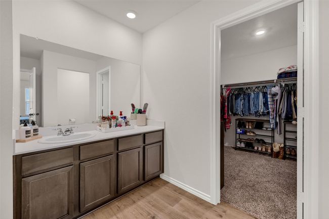 Bathroom with vanity, a walk in closet, wood finished floors, and recessed lighting | Image 21