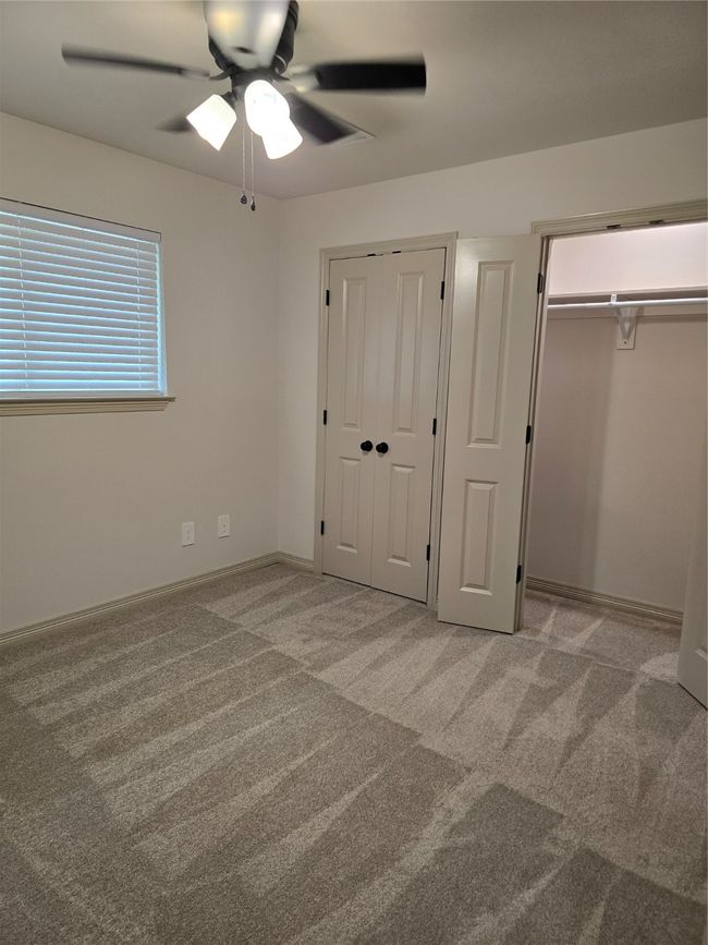 Bedroom with large closet, carpet, and ceiling fan | Image 16