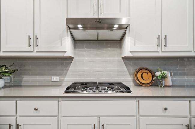 Kitchen featuring extractor fan, stainless steel gas cooktop, and white cabinets | Image 10