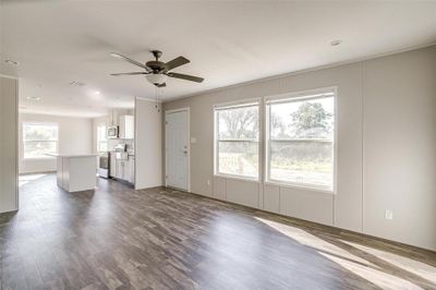 Unfurnished living room with ceiling fan and wood-type flooring | Image 3