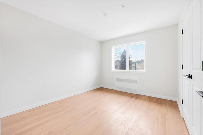 Empty room featuring radiator and light wood-type flooring | Image 38
