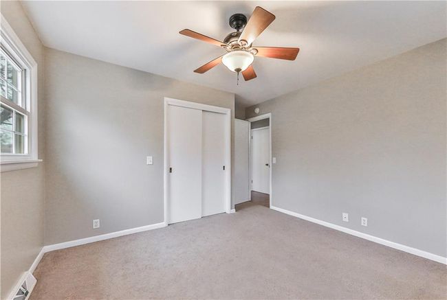 Unfurnished bedroom featuring light carpet, a closet, and ceiling fan | Image 15