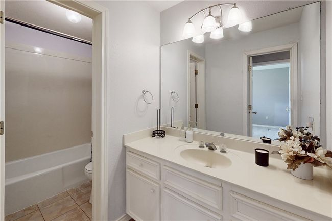 Bathroom featuring toilet, vanity, tile patterned floors, and shower / washtub combination | Image 16