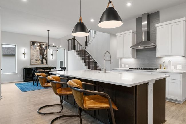 Elegant light fixtures, under-cabinet lighting, and recessed lighting that shimmers off of the stainless steel appliances. | Image 13
