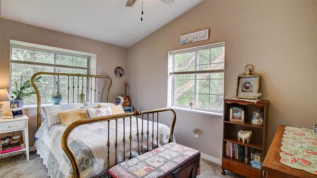 Carpeted bedroom featuring vaulted ceiling, a textured wall, and ceiling fan | Image 23