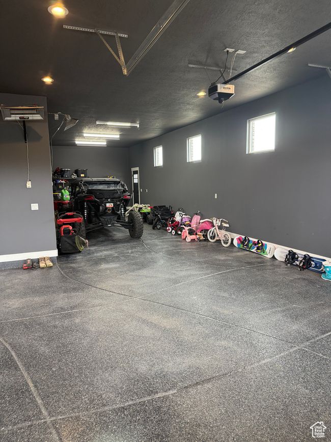 Garage with a garage door opener and baseboards | Image 30