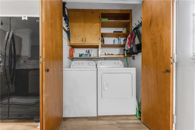 Washroom with washing machine and clothes dryer, cabinet space, and light wood-style floors | Image 10
