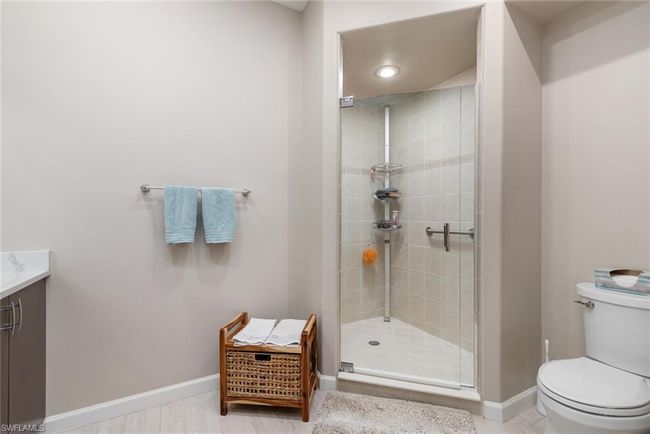 Bathroom with vanity, a shower with door, and toilet | Image 13