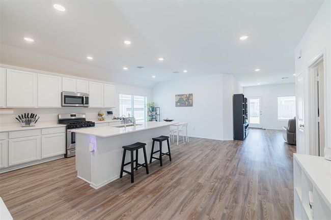 Island kitchen and breakfast room boasts quartz counters and breakfast bar. | Image 4