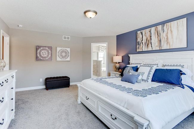 An oasis on it's own, the home's primary suite is awesome & loaded - including immediate access to a private bath that is equally appointed with features & TWO oversized walk-in closets! Photo of model home, color & options may vary. | Image 12