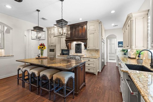 Notice the ample cabinet space and endless countertops. The gorgeous vent hood is also a perfect focal point. The window over the sink looks outside and allows natural light to easily enter the room. | Image 21